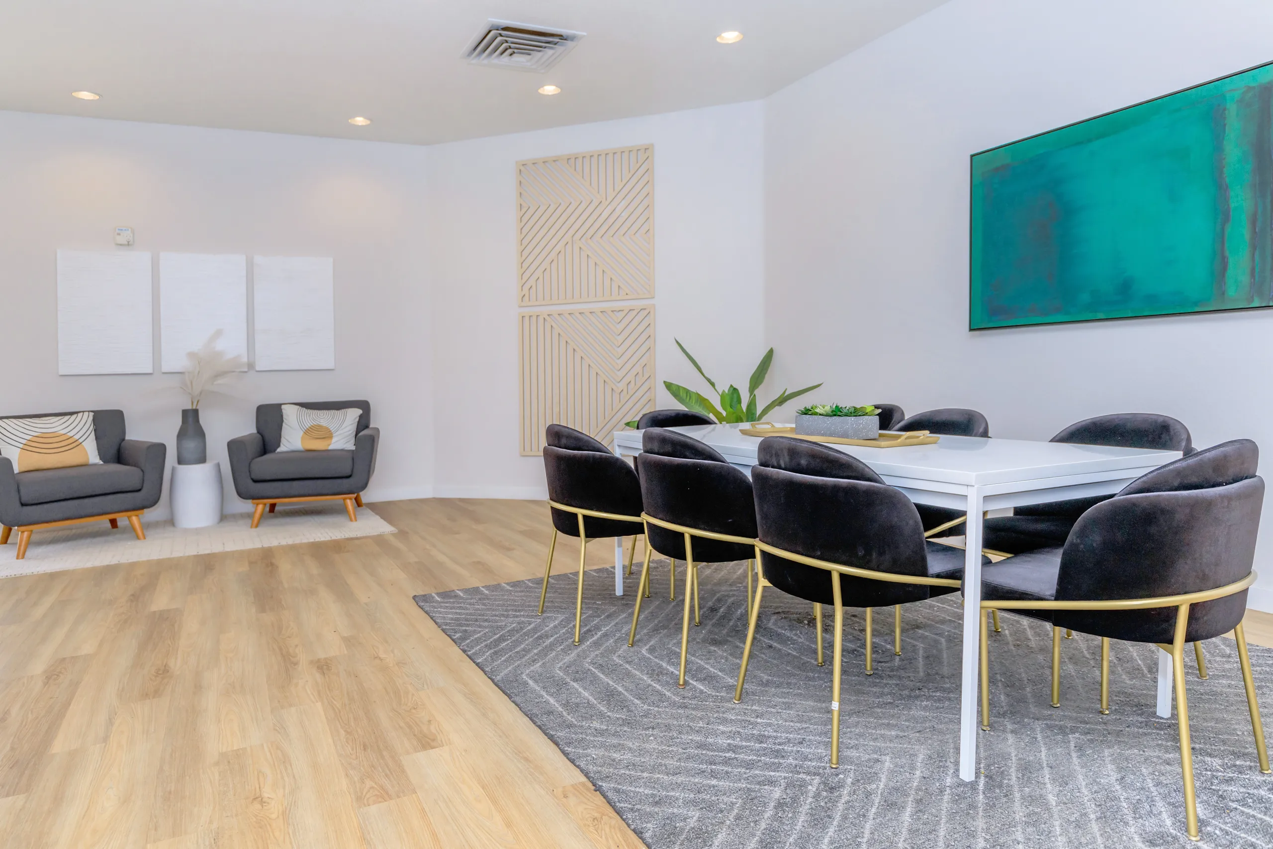 Community lounge dining table, lounge seating, wall art, wood-style plank flooring
