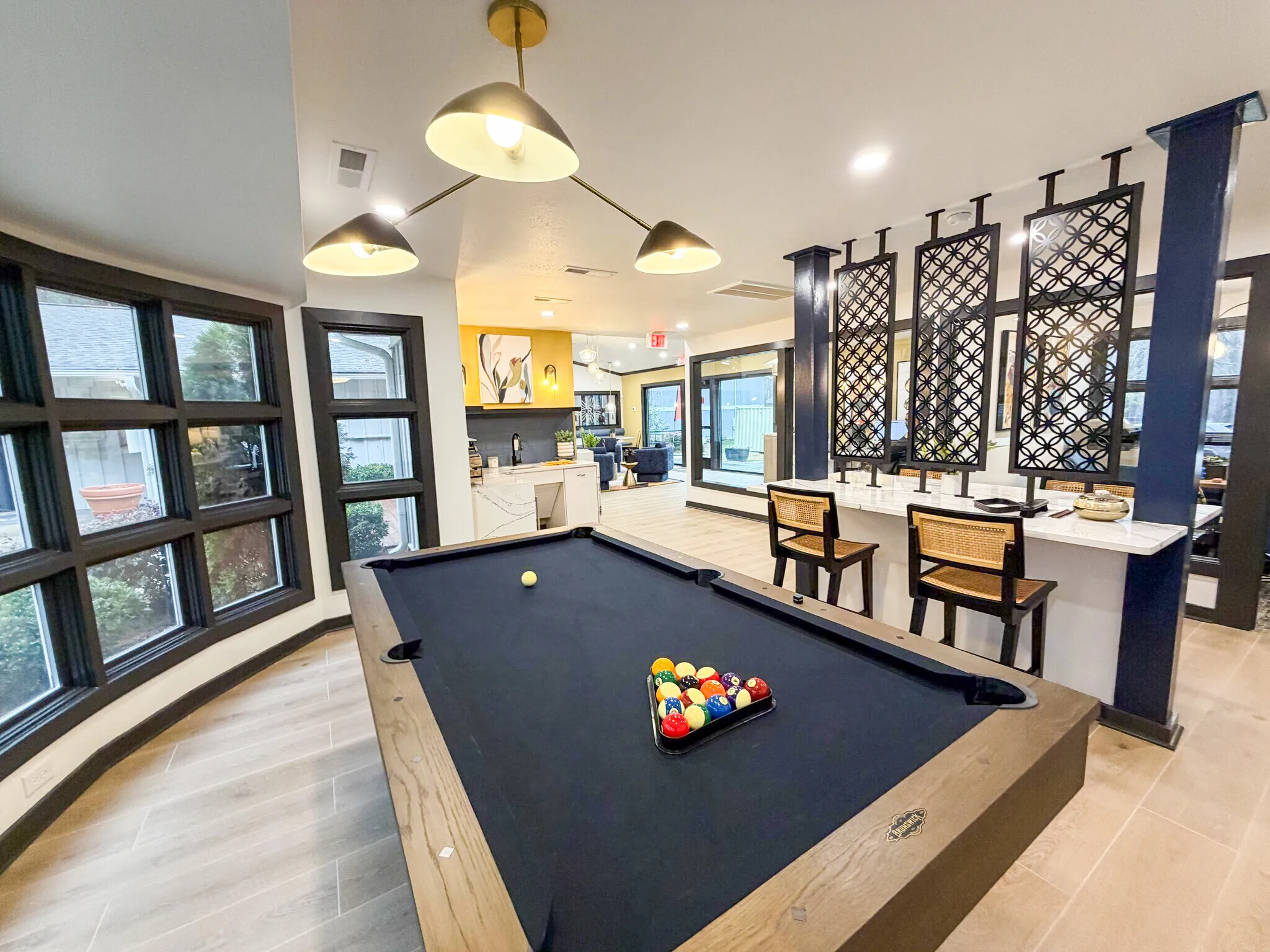 Game room, billiards table, pendant lighting, wood-style plank flooring, large windows