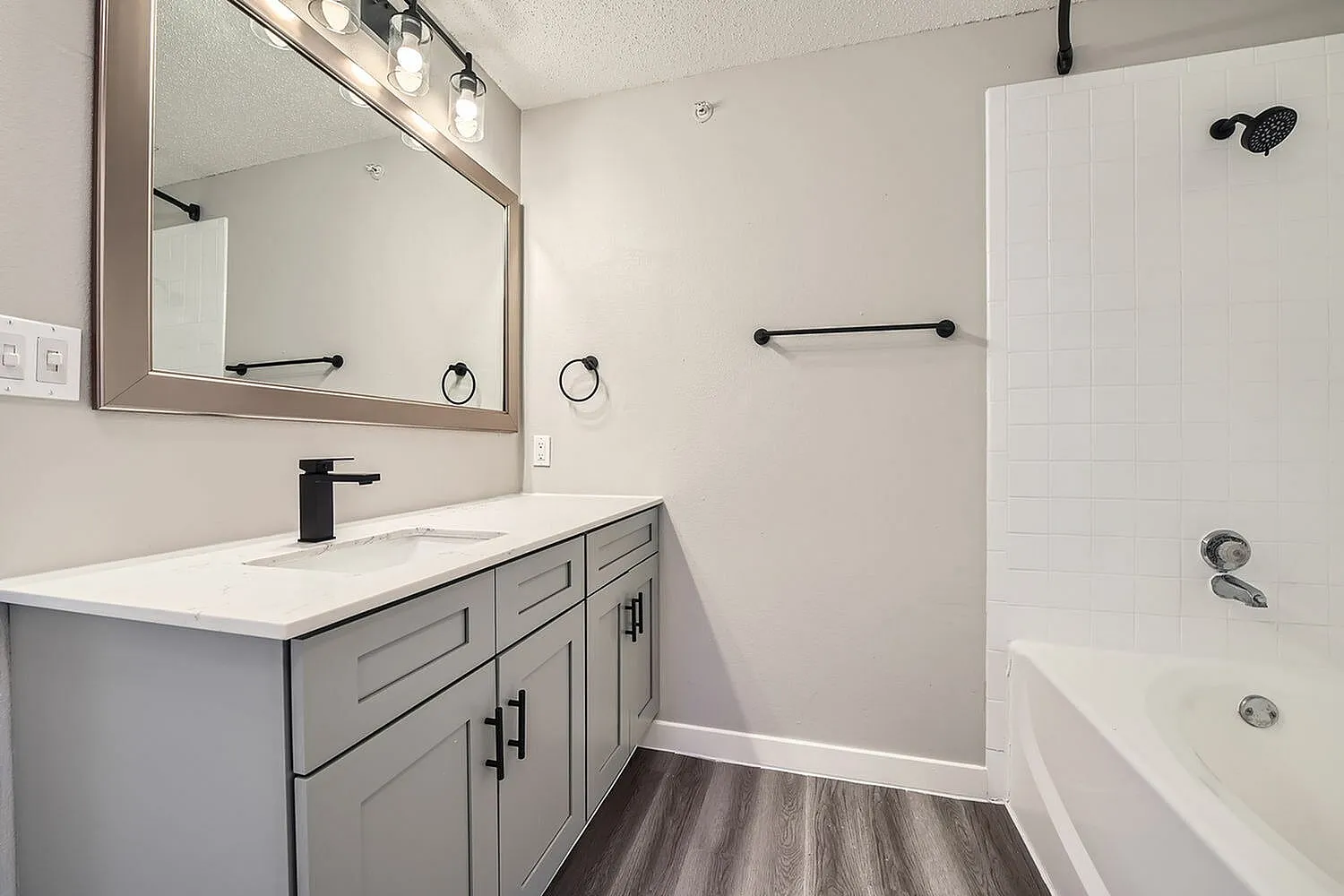 Bathroom vanity, white countertop, gray cabinet, tub shower combo