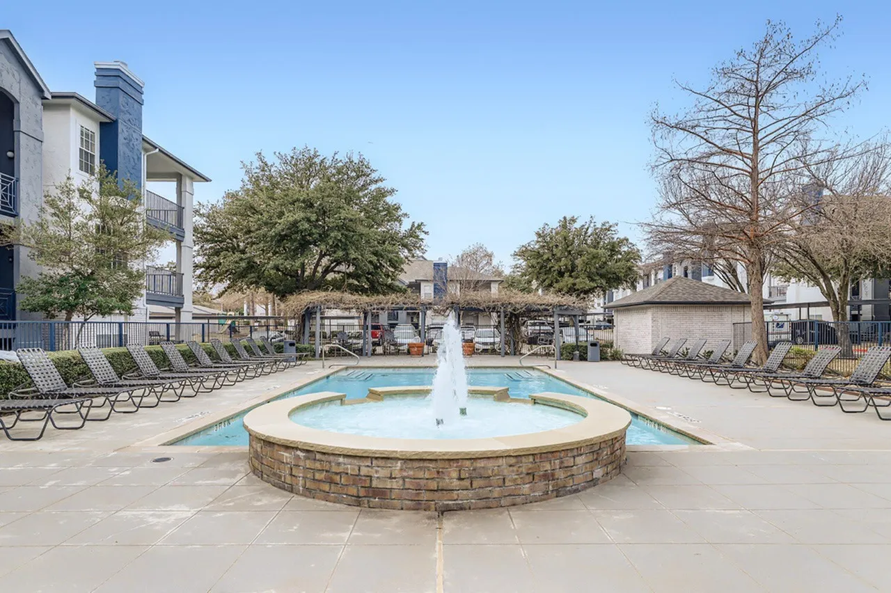 Pool fountain feature, lounge chairs, pergola, landscaped trees