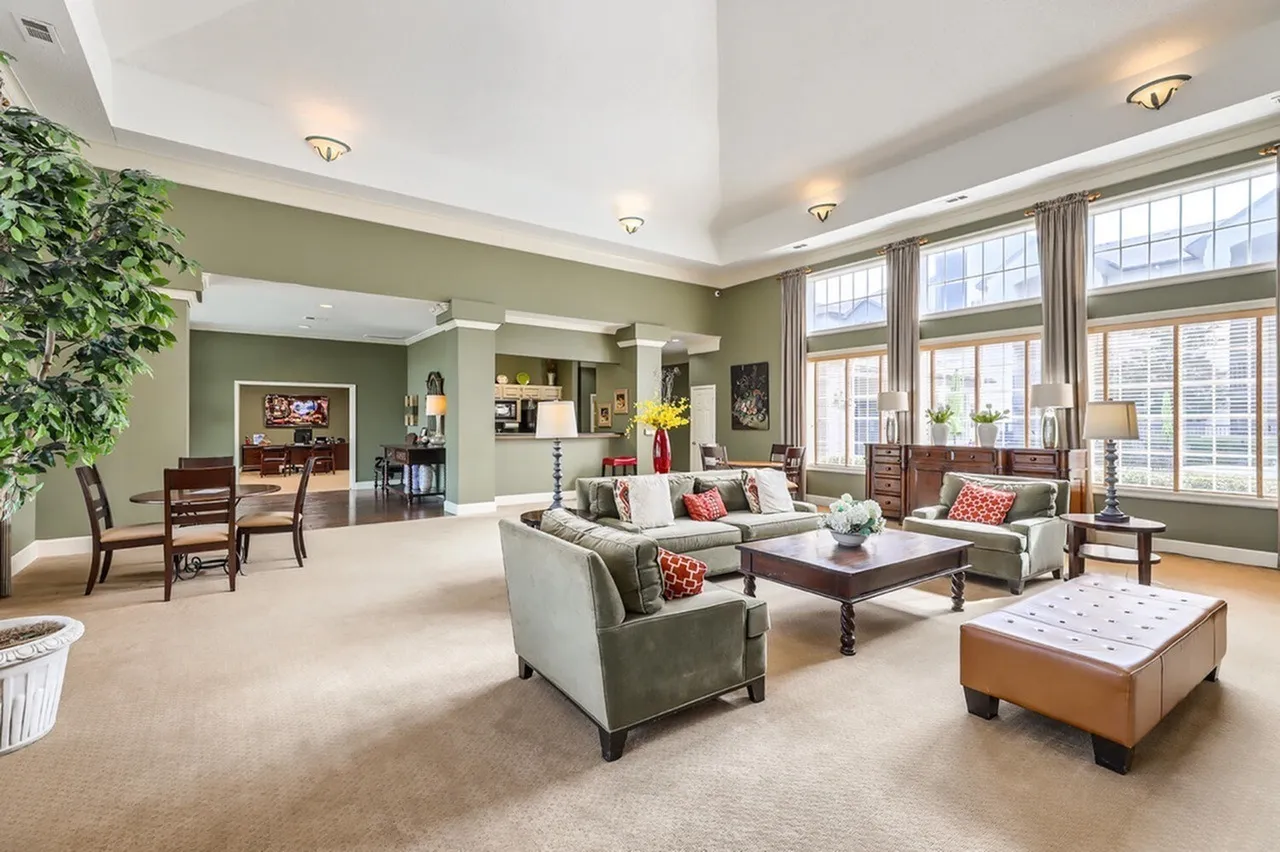 Clubhouse lounge, sofa seating, coffee table, vaulted ceiling, large windows