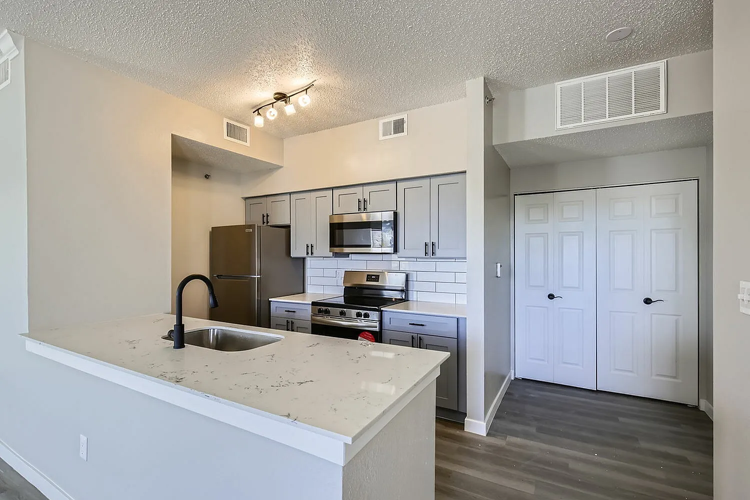 Kitchen, white countertop, gray cabinetry, subway tile backsplash