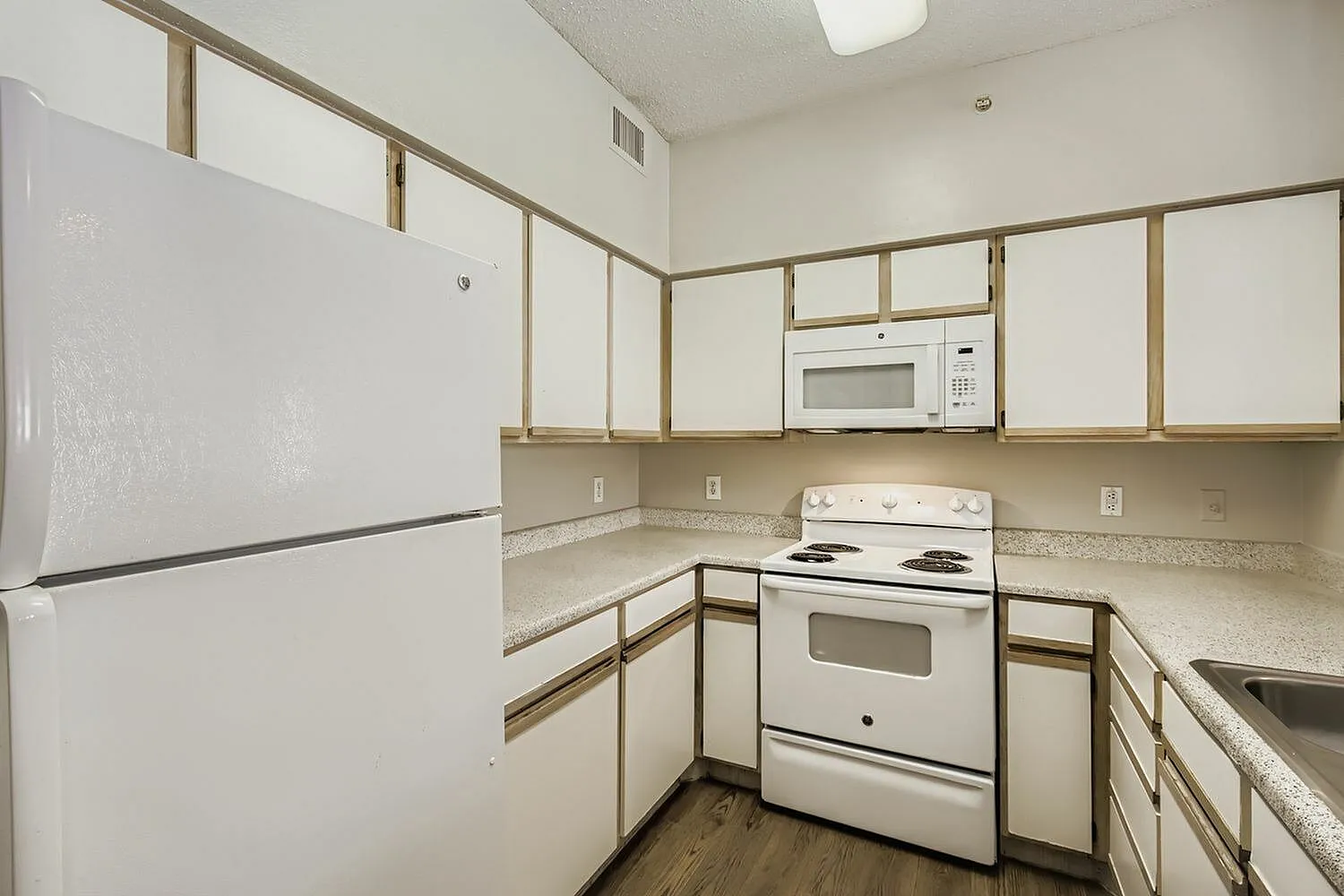 Kitchen, white refrigerator, over-range microwave, wood-trim cabinetry