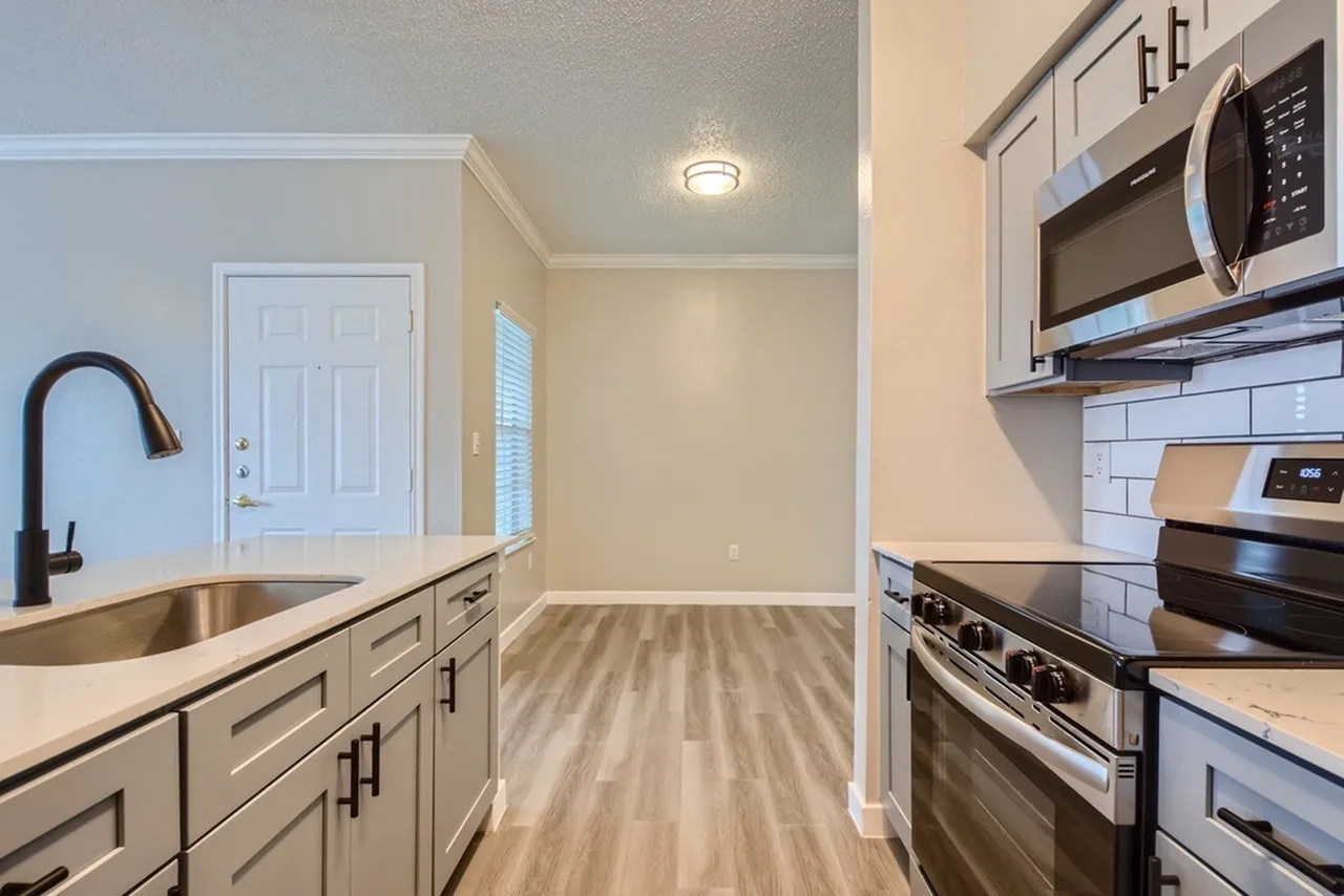 Kitchen, wood-style plank flooring, gray cabinetry