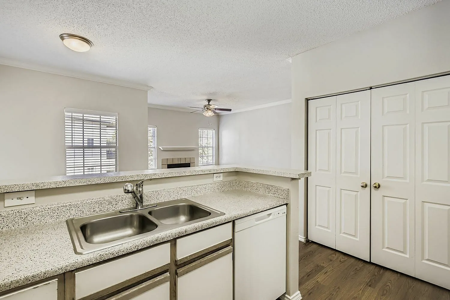 Kitchen sink, speckled countertop, breakfast bar, fireplace view