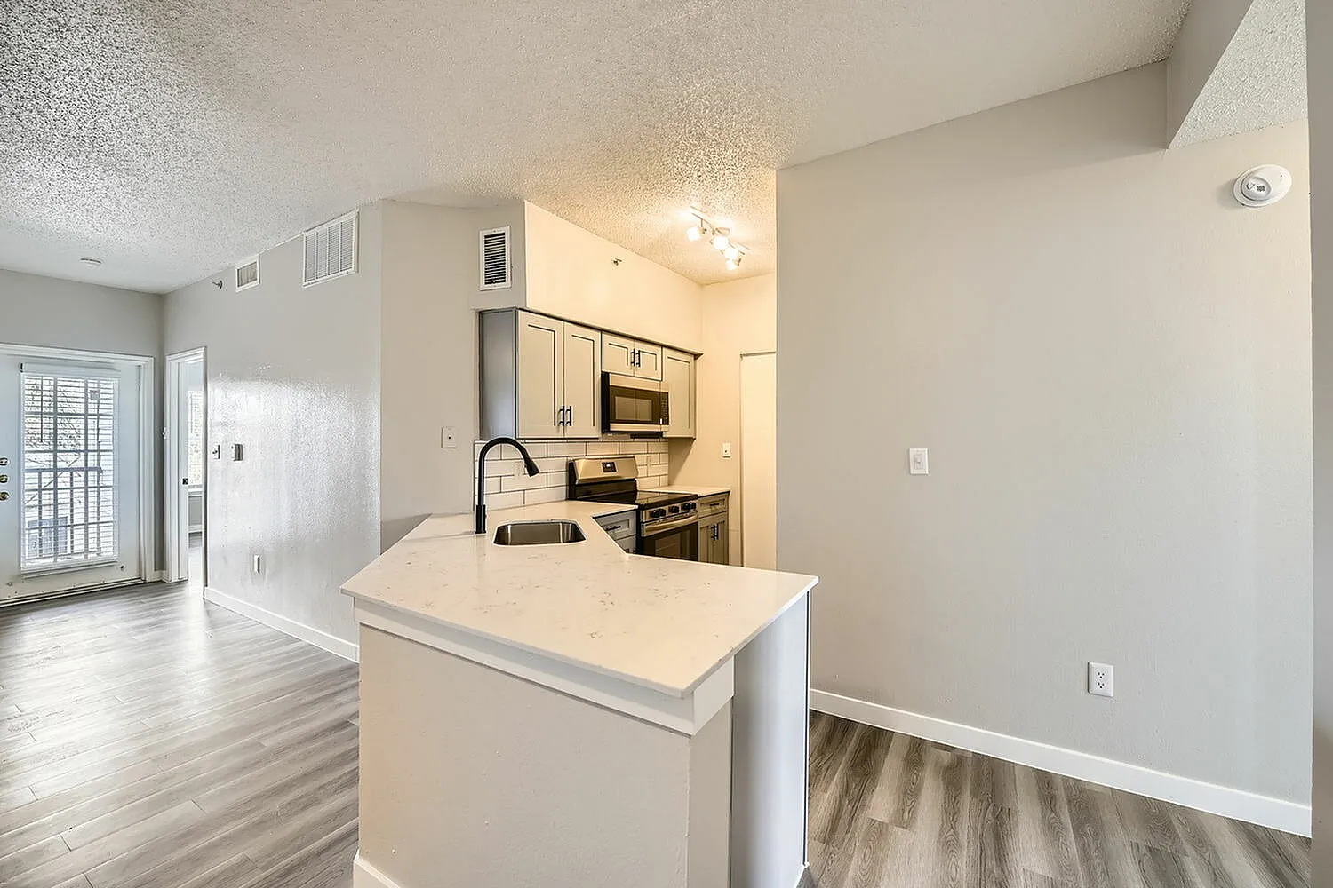 Kitchen peninsula, white countertop, gray cabinetry