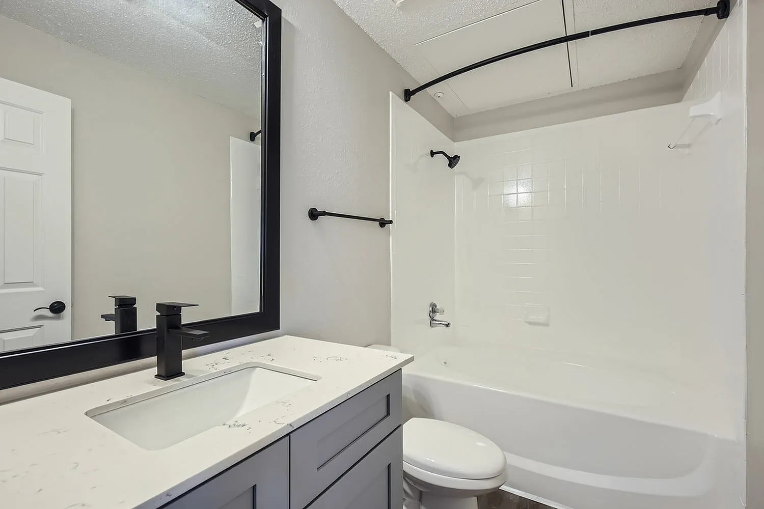 Tub shower, black fixtures, framed mirror