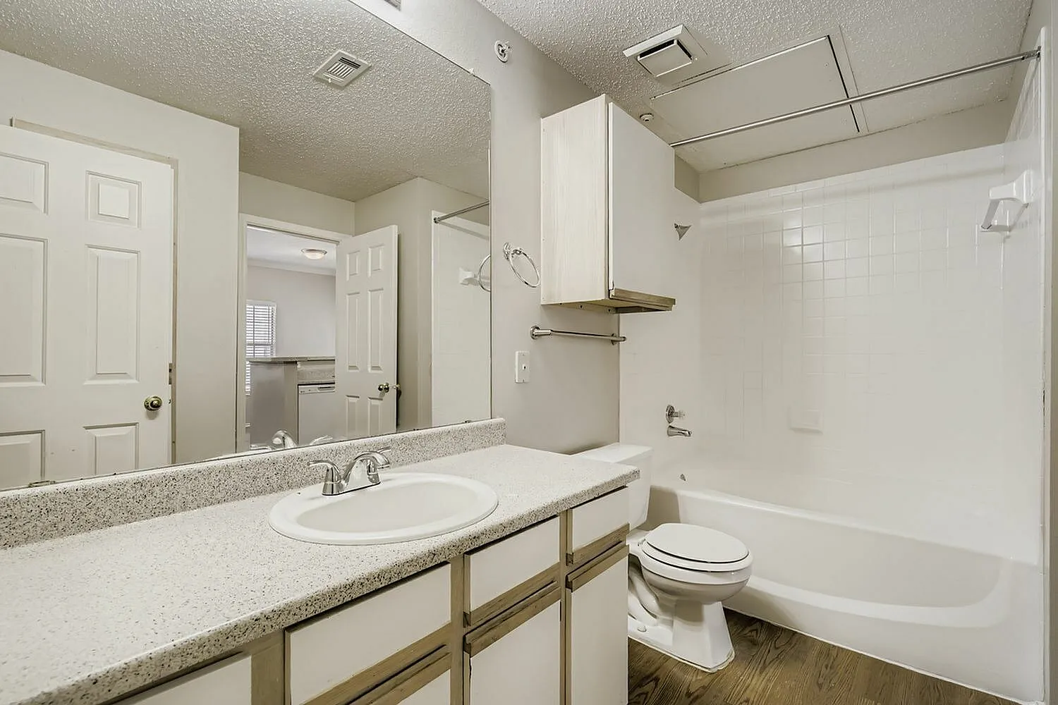 Bathroom vanity, speckled countertop, tub shower