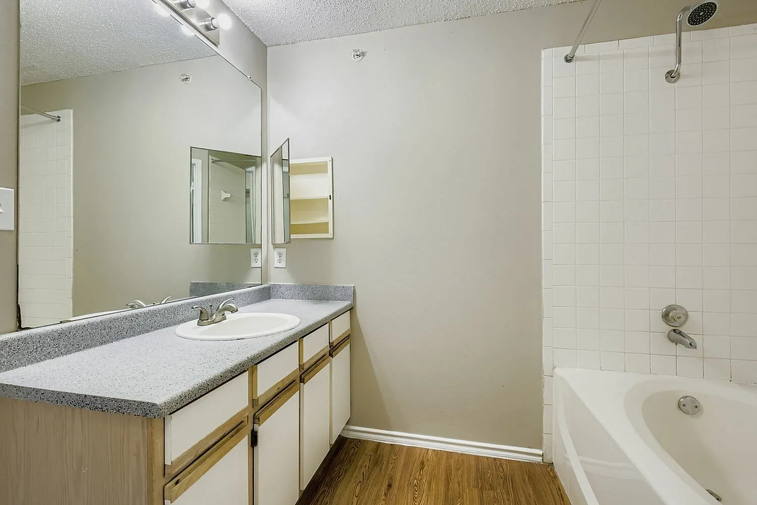 Bathroom vanity, speckled countertop, wood-trim cabinet, medicine cabinet mirror