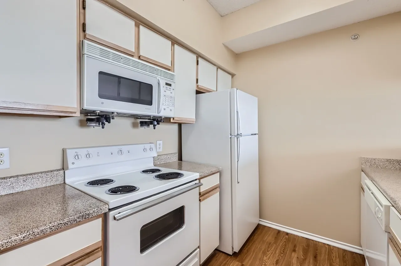 Kitchen, white appliances, white cabinetry with wood trim