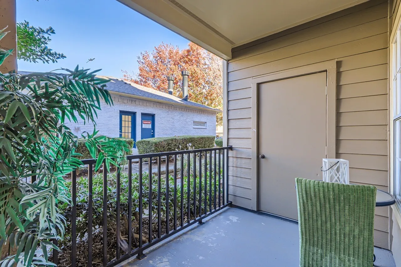 Covered balcony, metal railing, building exterior, mature trees