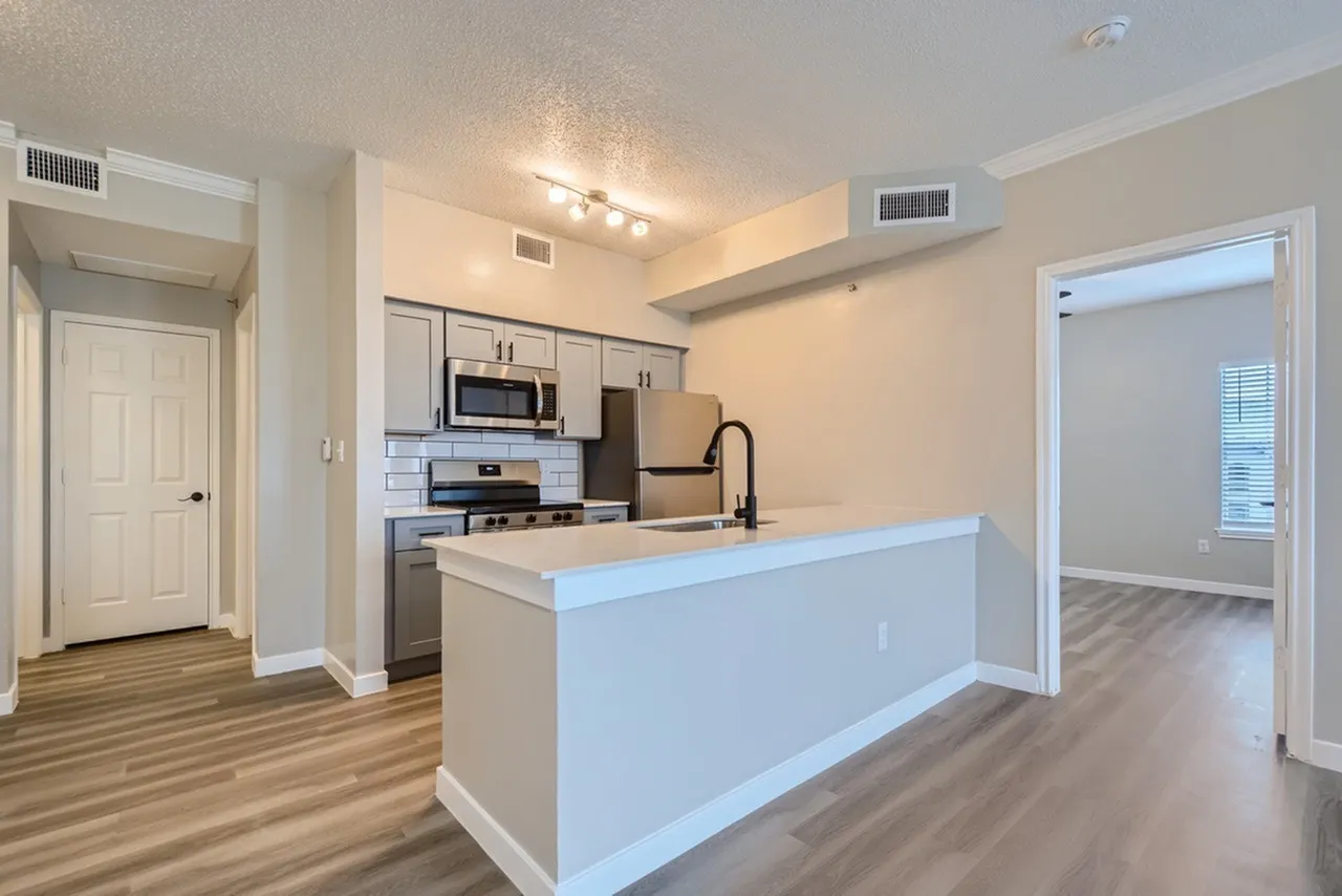 Kitchen peninsula, white countertop, stainless steel appliances