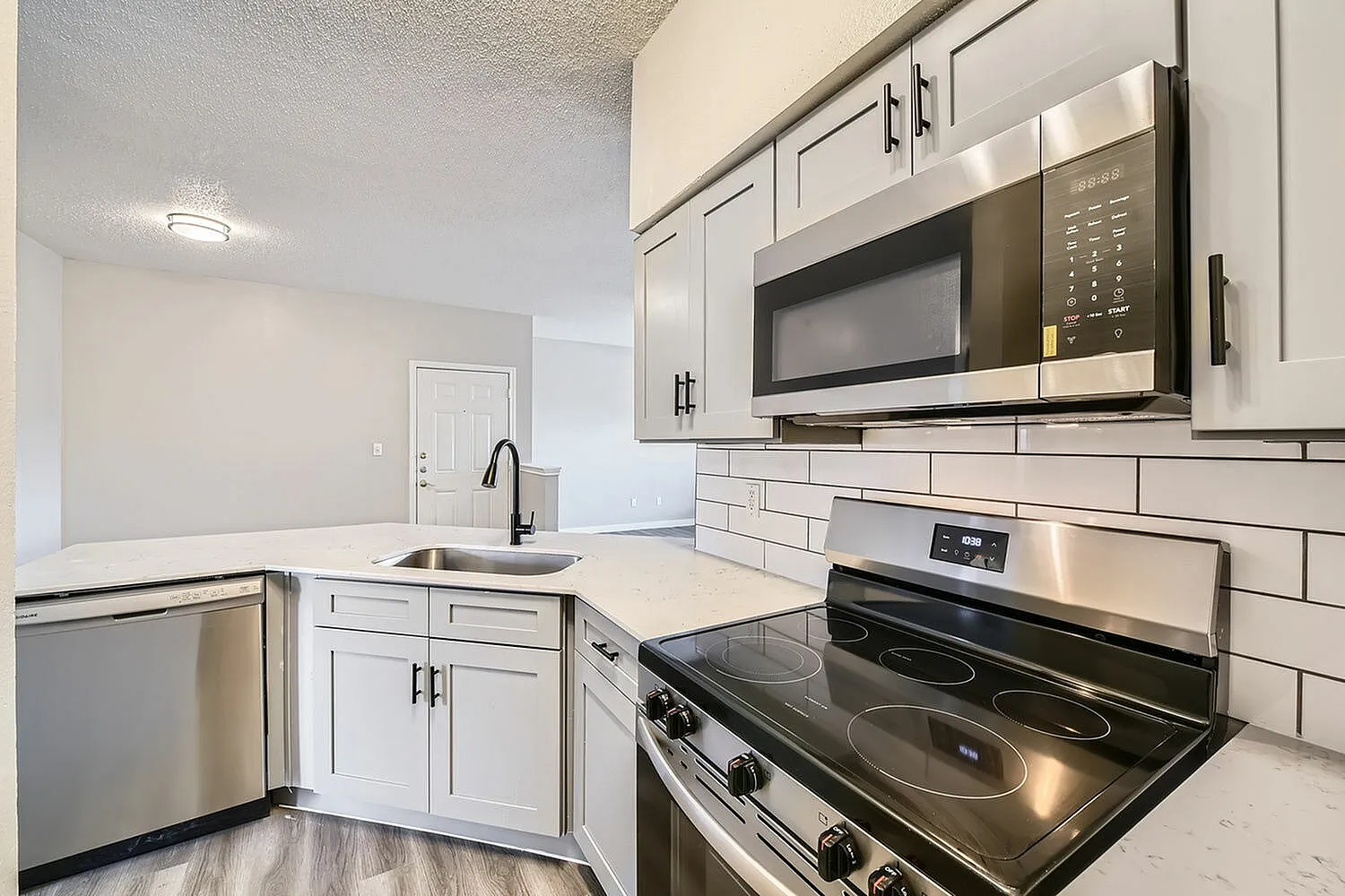 Stainless steel microwave, electric range, subway tile backsplash