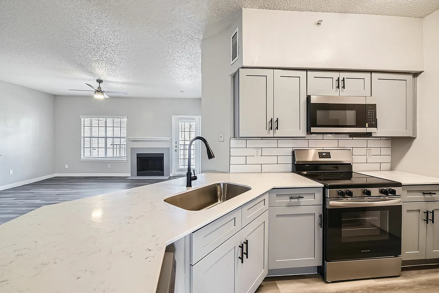 Kitchen, subway tile backsplash, black faucet, gray cabinetry