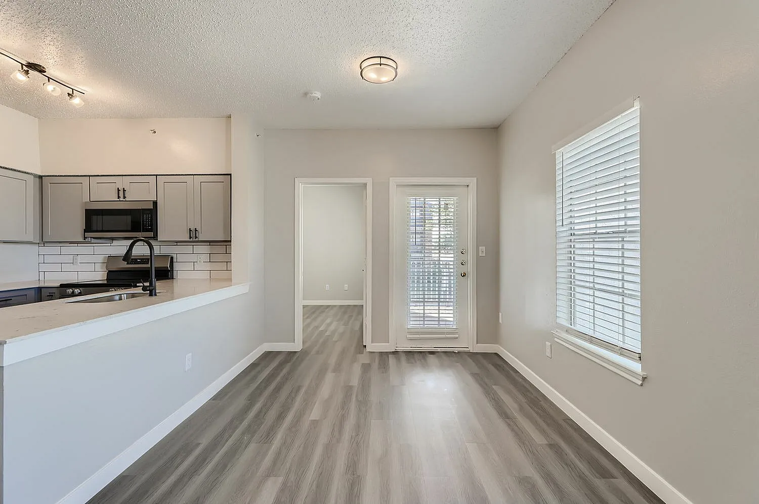 Kitchen peninsula, wood-style plank flooring, door to balcony