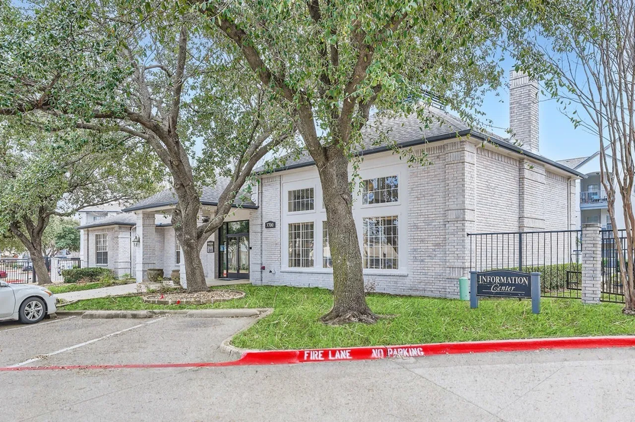 Clubhouse exterior, brick building, mature trees, entrance walkway