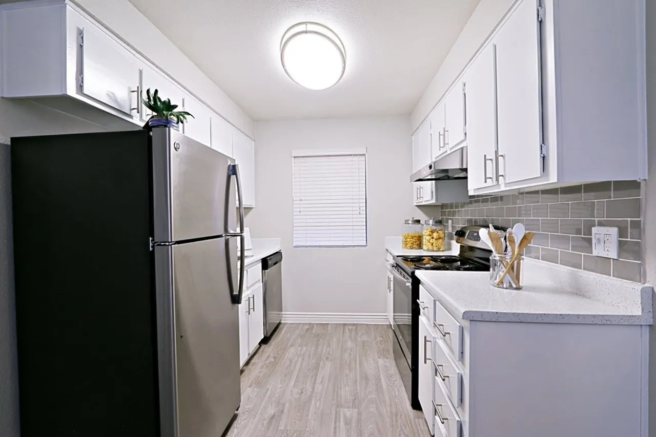 Kitchen, white shaker cabinetry, gray subway tile backsplash, stainless appliances, wood-style plank flooring