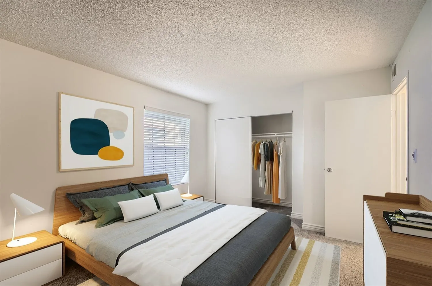Primary bedroom, wood-style plank flooring, open closet with hanging clothes, framed abstract wall art