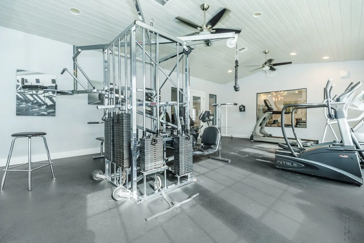 Fitness center, multi-station weight machine, treadmill, ceiling fan, polished concrete flooring