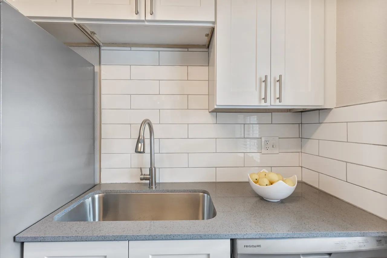 Kitchen, white shaker cabinetry, gray quartz countertops, stainless steel sink, subway tile backsplash