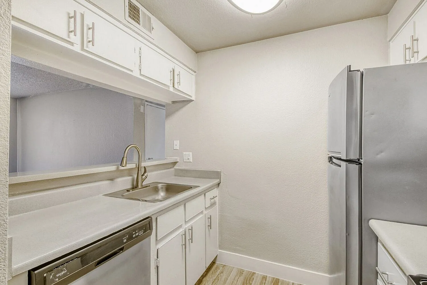 Kitchen, white shaker cabinetry, stainless steel appliances, quartz countertops, wood-style plank flooring