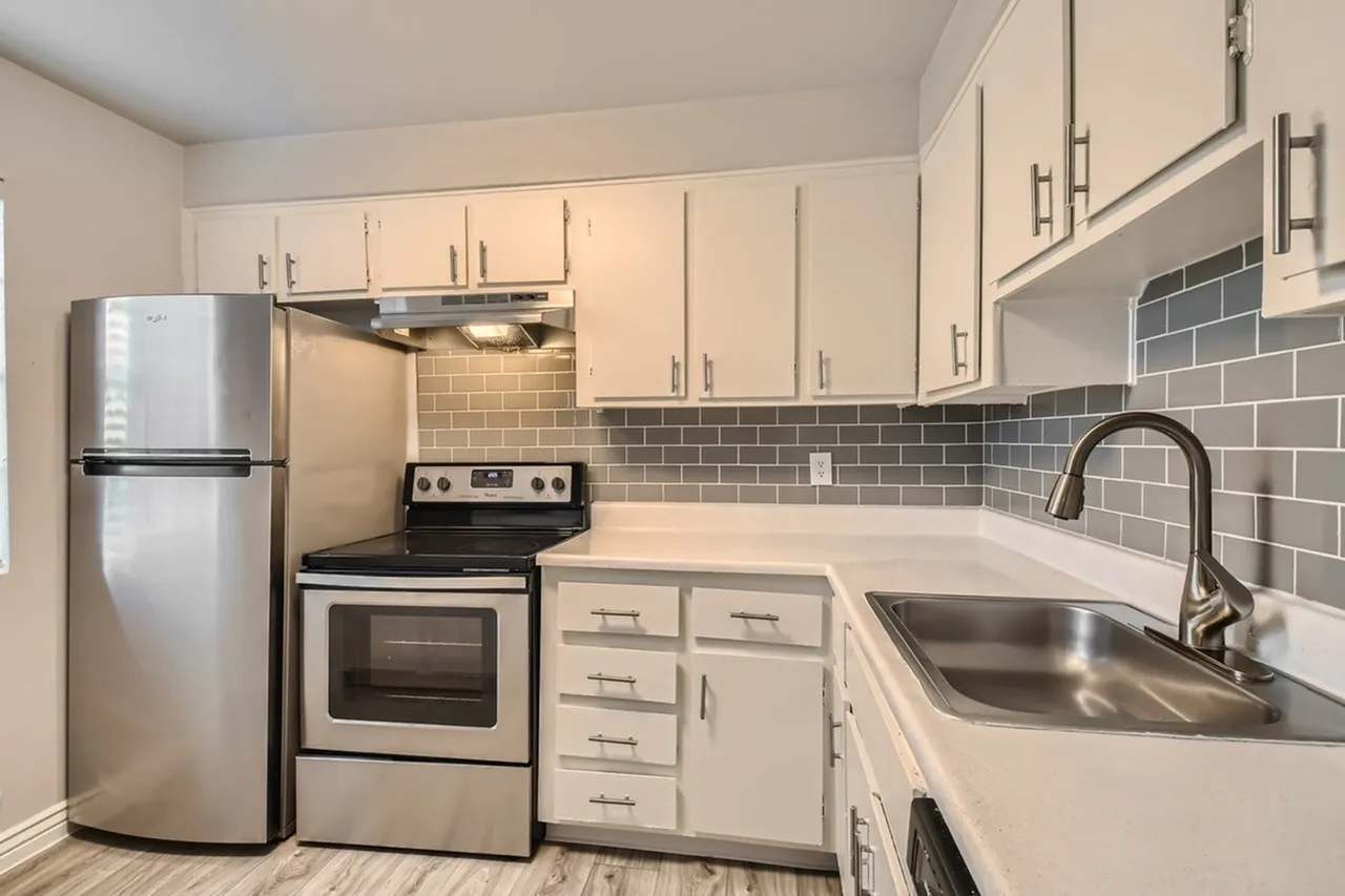 Kitchen, white shaker cabinetry, gray subway tile backsplash, stainless steel appliances, wood-style plank flooring