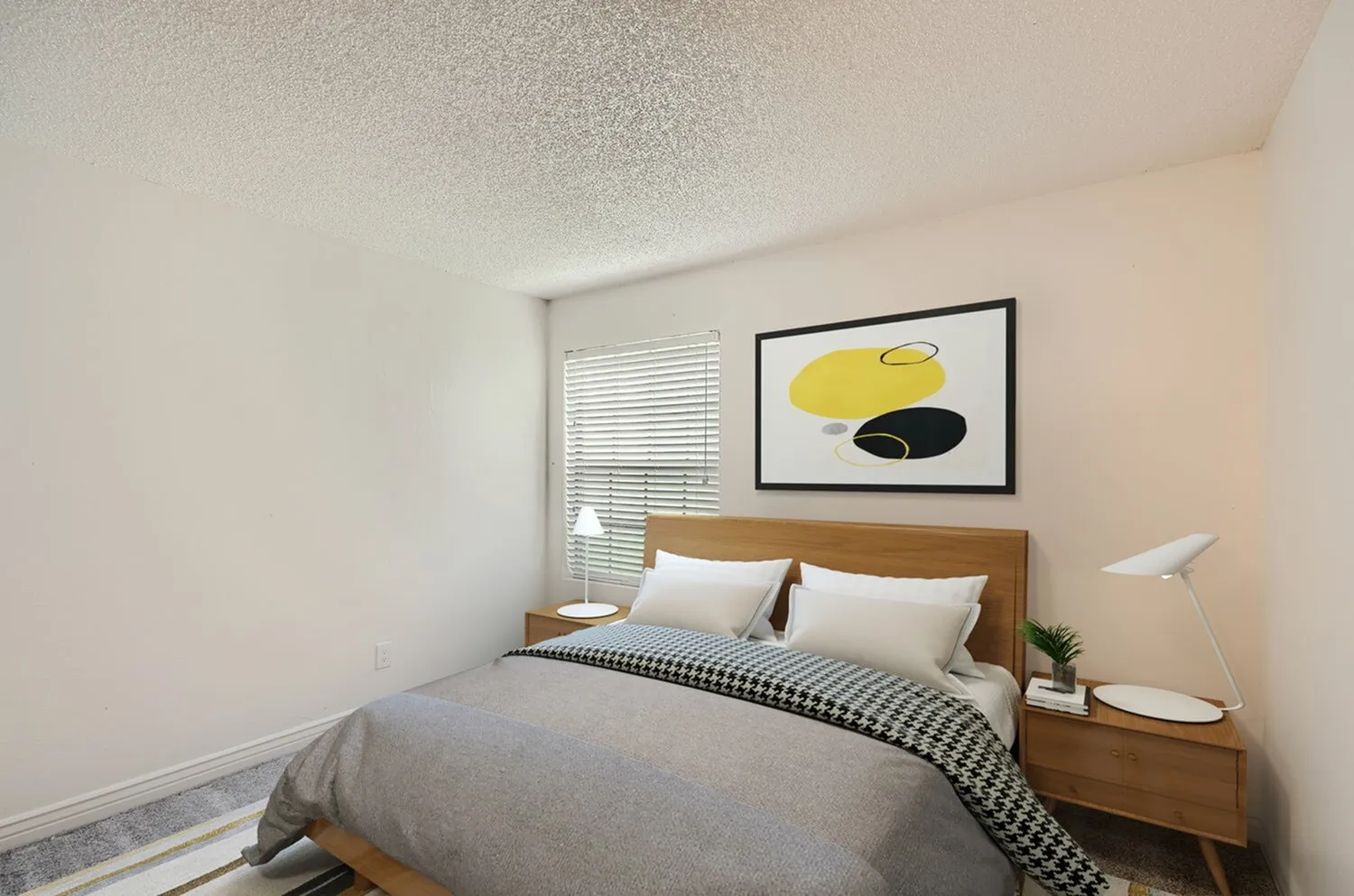 Primary bedroom, wood-style bed frame, white bedding, geometric wall art, blinds