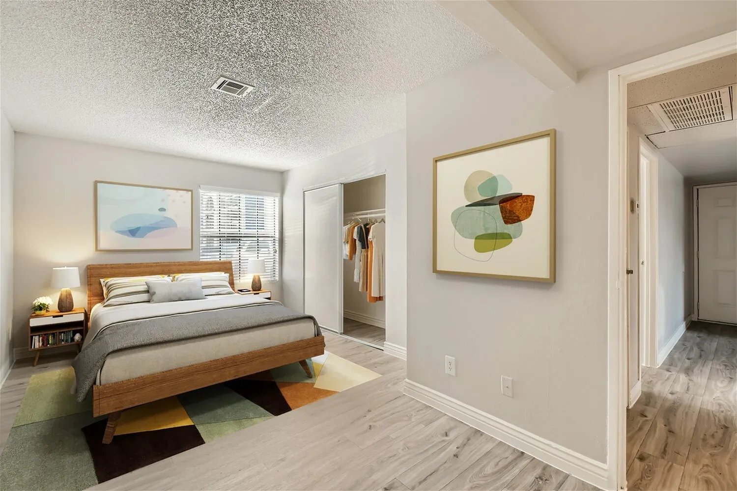 Primary bedroom, wood bed frame, wood-style plank flooring, walk-in closet, abstract wall art