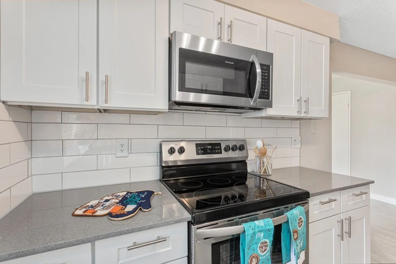 Kitchen, white shaker cabinetry, gray quartz countertops, stainless steel appliances