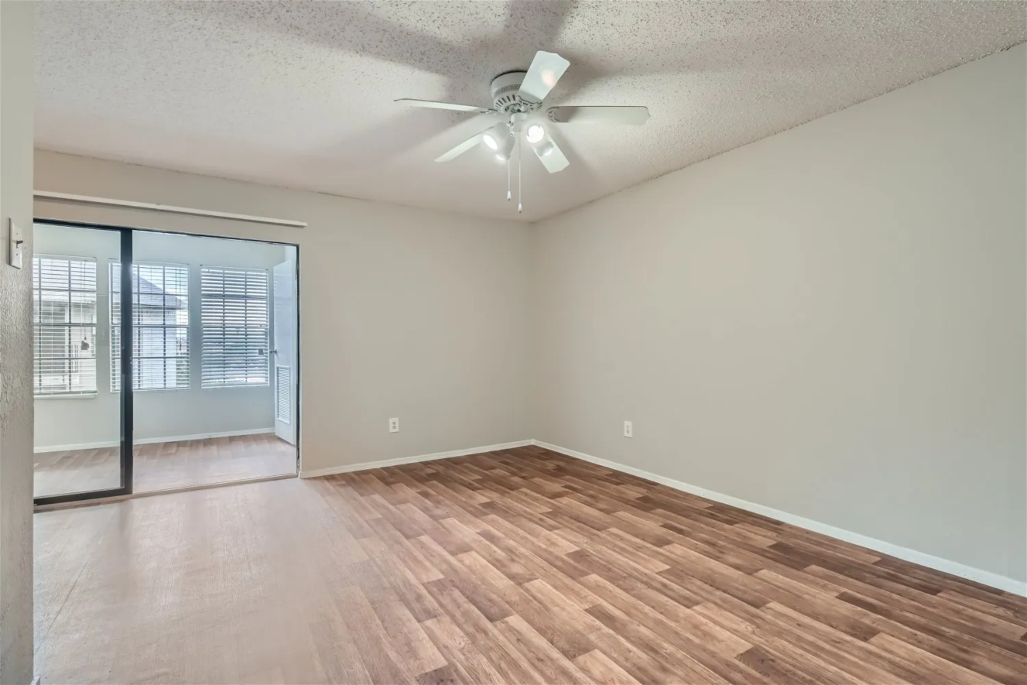 A5 Classic living room, wood-style plank flooring, ceiling fan, sunroom access