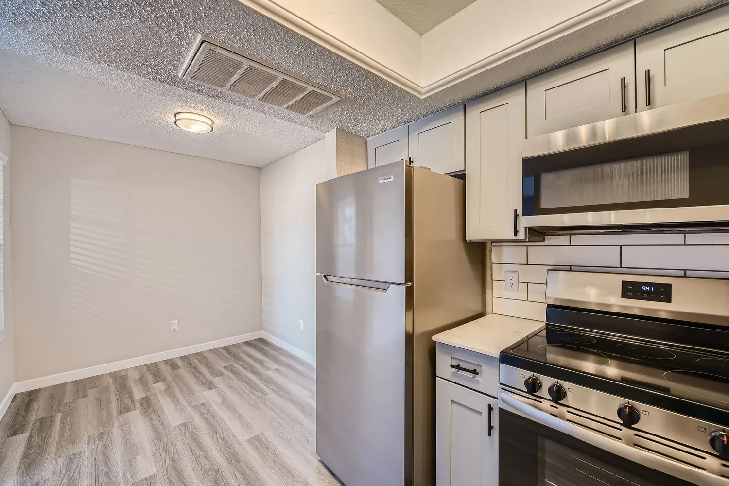 Kitchen with refrigerator, range, and microwave, gray shaker cabinets