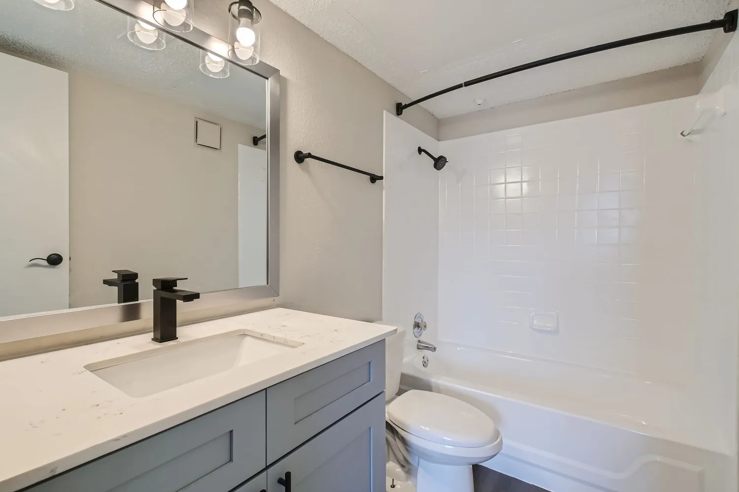 Primary bathroom vanity, quartz countertop, matte black fixtures, tub and shower