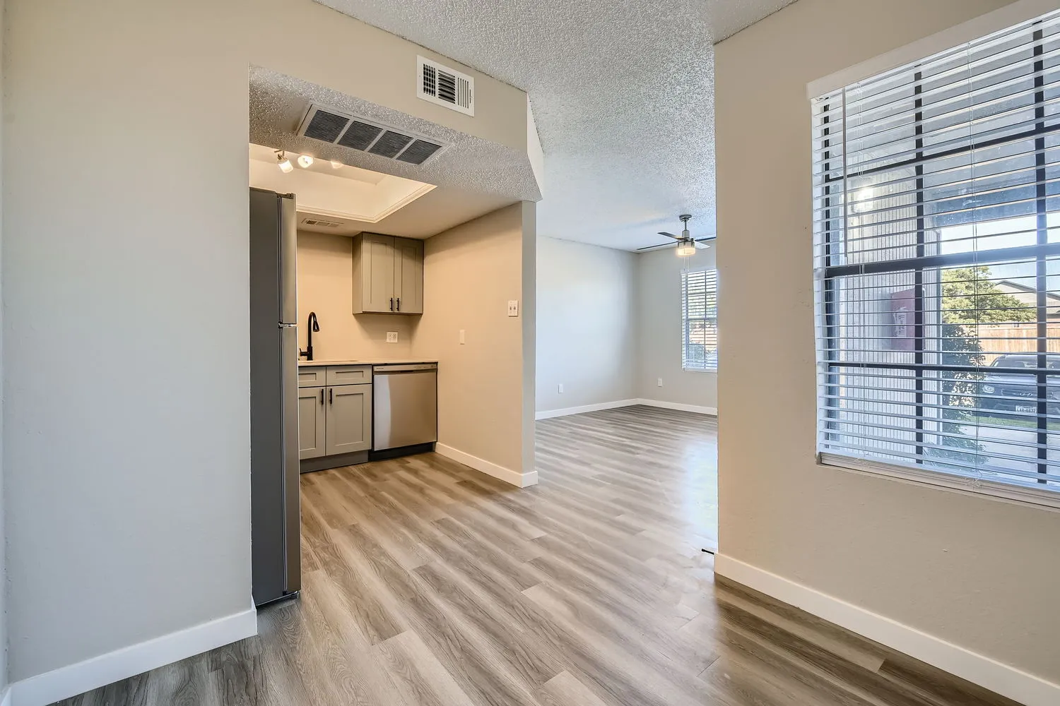 Dining room open to kitchen, wood-style plank flooring, large window