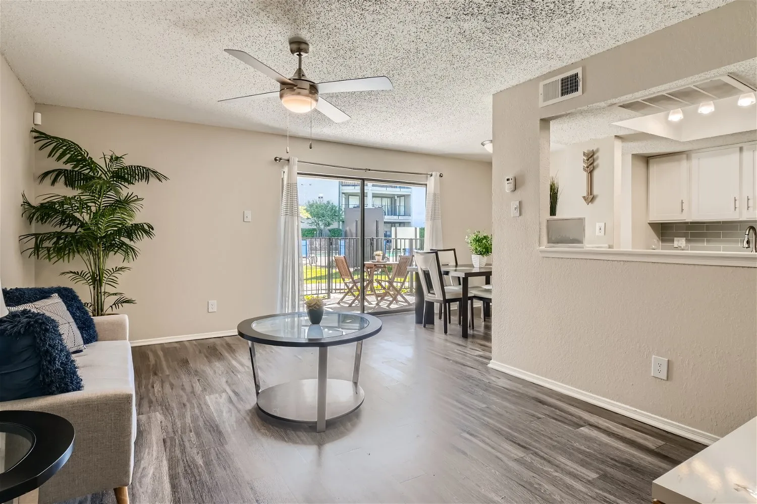 A4 Classic living room, wood-style plank flooring, ceiling fan, open to dining and kitchen