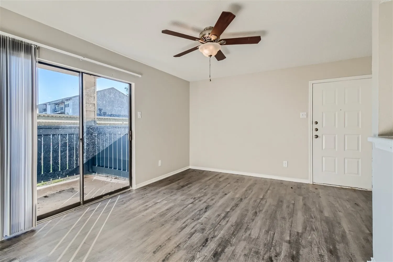 Living room, ceiling fan, sliding glass door, private balcony access