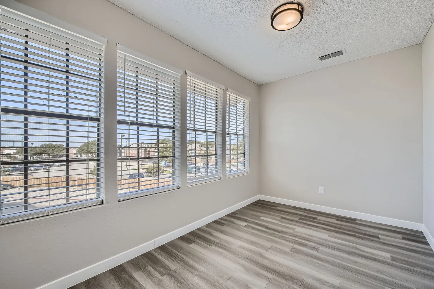 Sunroom with wall of windows, natural light, wood-style plank flooring