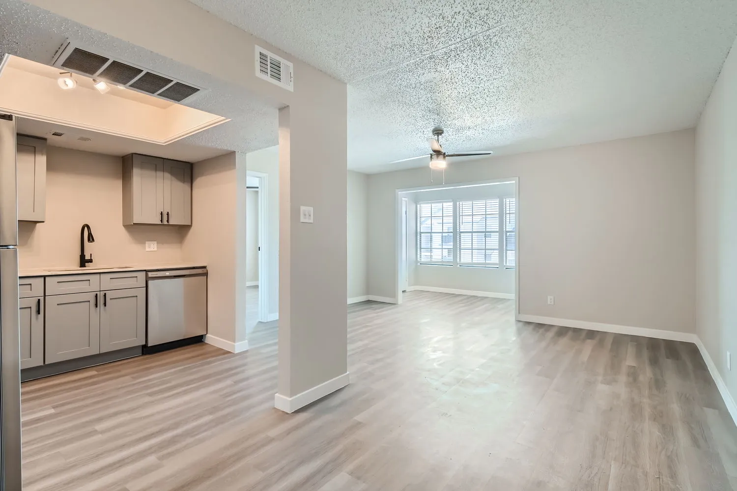 Dining room open to kitchen and sunroom, wood-style plank flooring