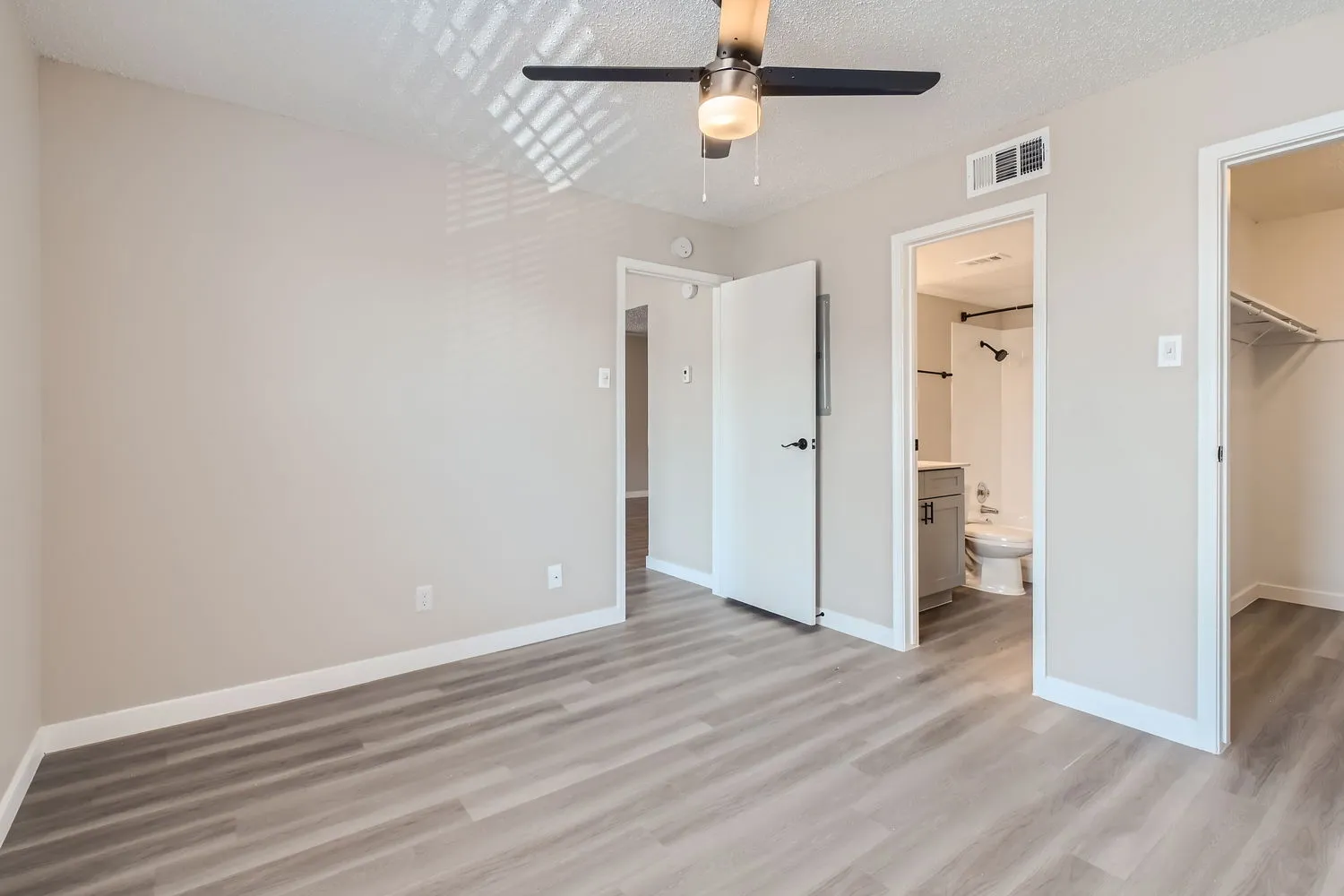 Primary bedroom, en-suite bathroom and walk-in closet access, ceiling fan