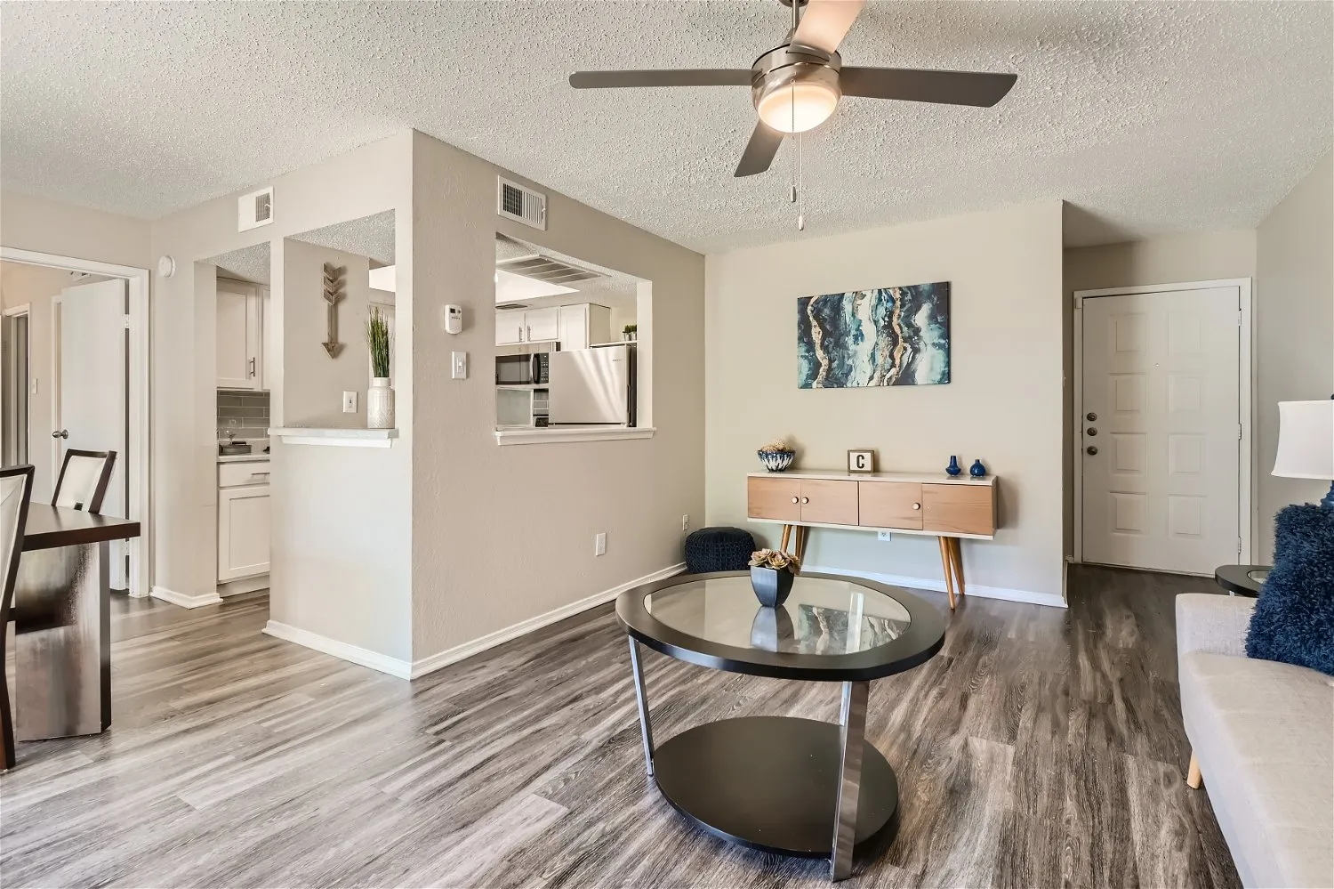 Living room, ceiling fan, entry door, open to kitchen