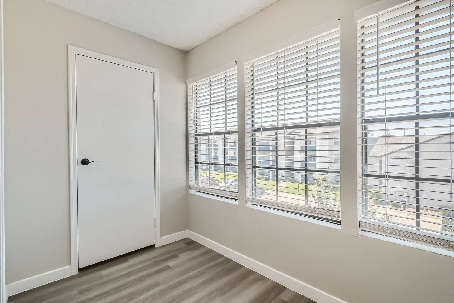 Sunroom, large windows, wood-style plank flooring