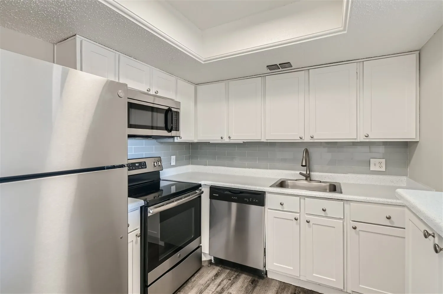 Kitchen, stainless steel appliances, white cabinetry, tile backsplash
