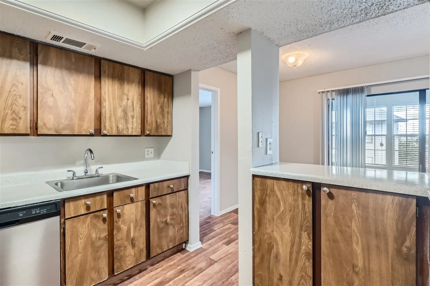 Kitchen counter with dishwasher and sink, sliding glass door view