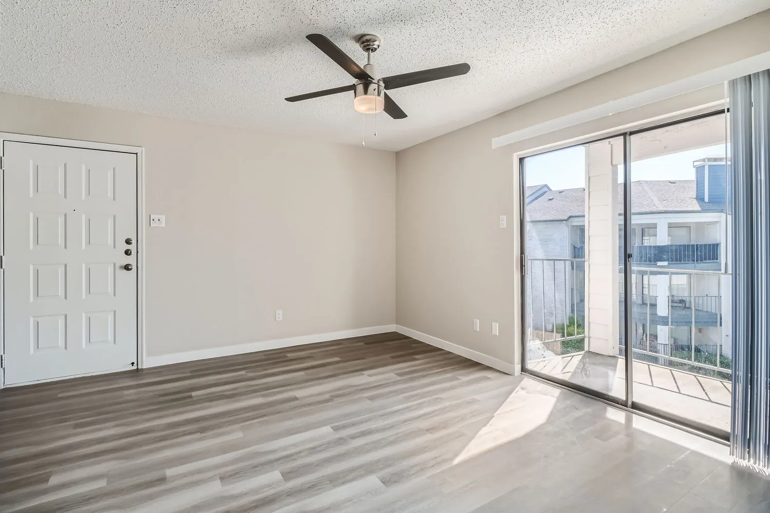 Living room, ceiling fan, sliding glass door, private balcony access