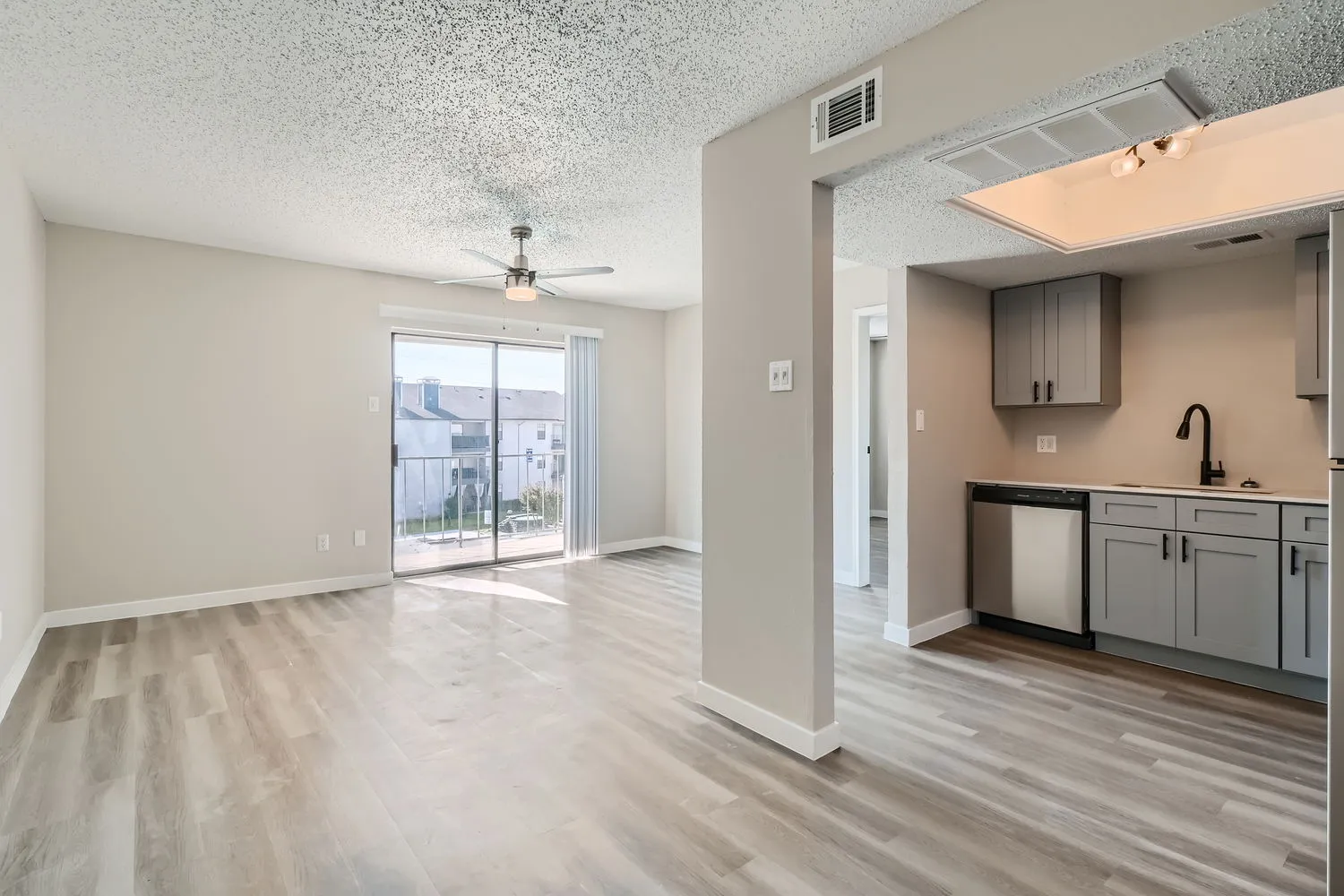 Dining room open to kitchen, sliding glass door, wood-style plank flooring
