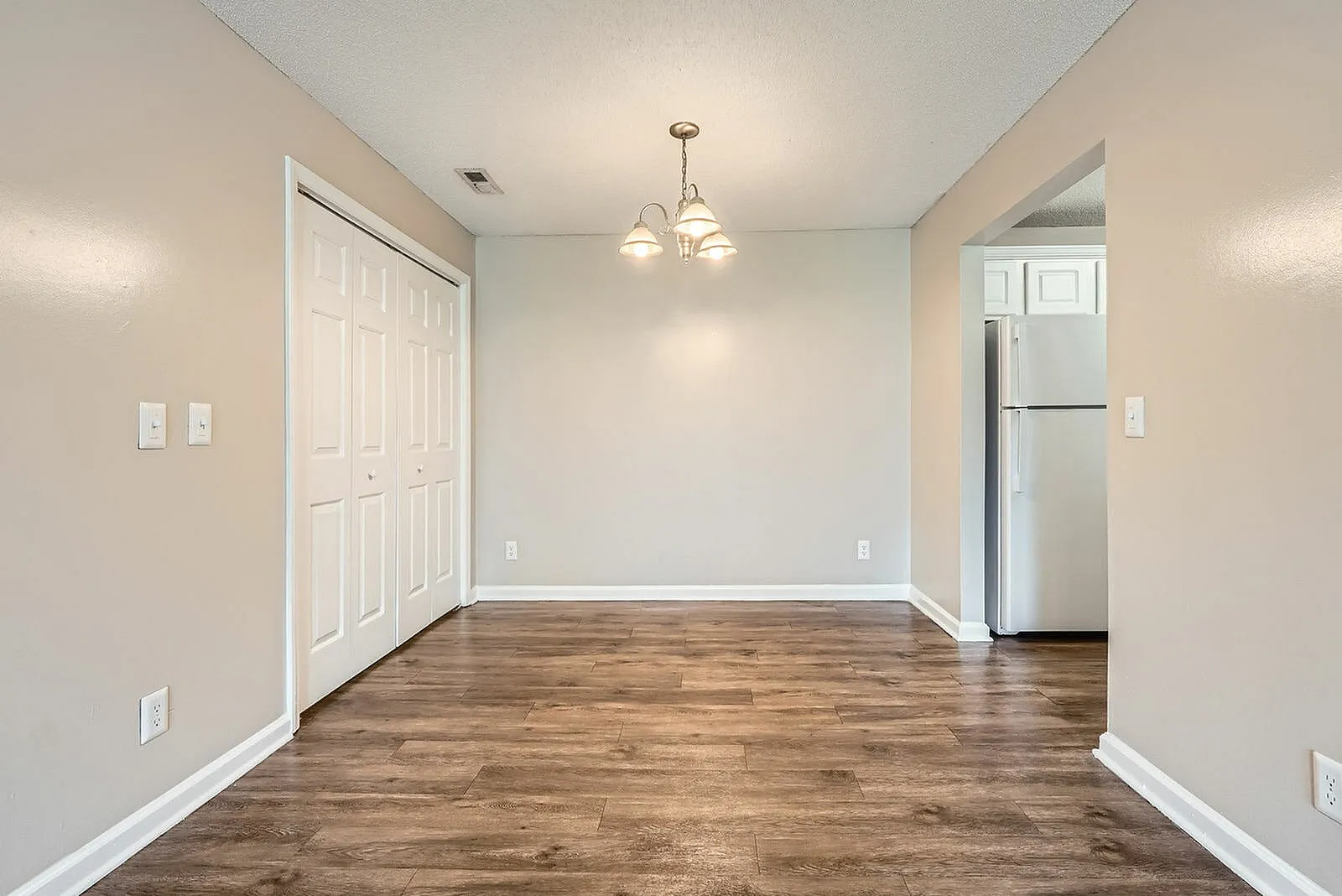 Dining room, wood-style plank flooring, pendant lighting, white trim, neutral walls