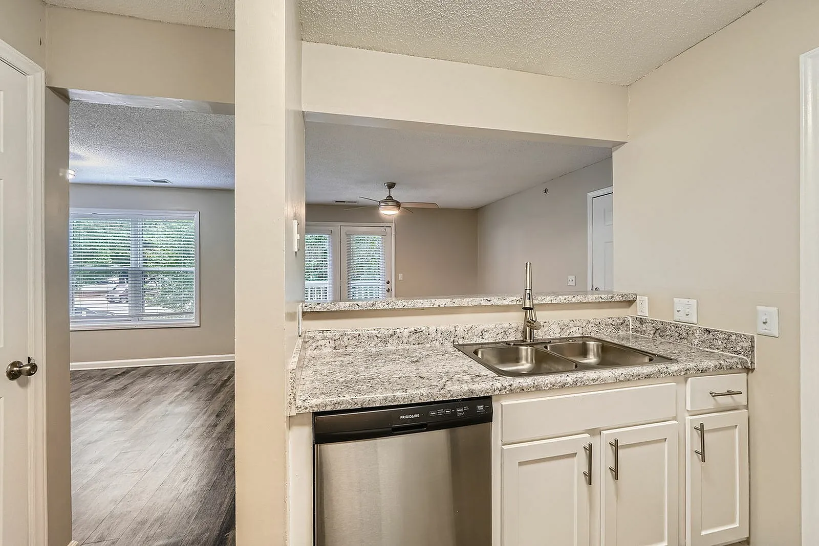 Kitchen, granite countertops, white shaker cabinetry, stainless steel sink, black dishwasher
