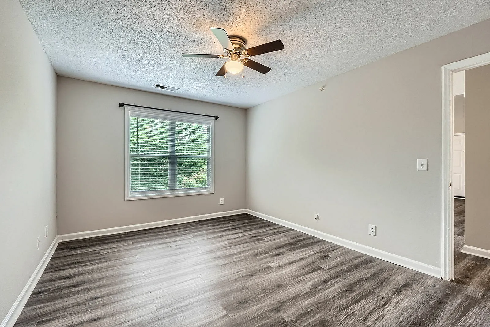 Bedroom, wood-style plank flooring, ceiling fan with light, large window
