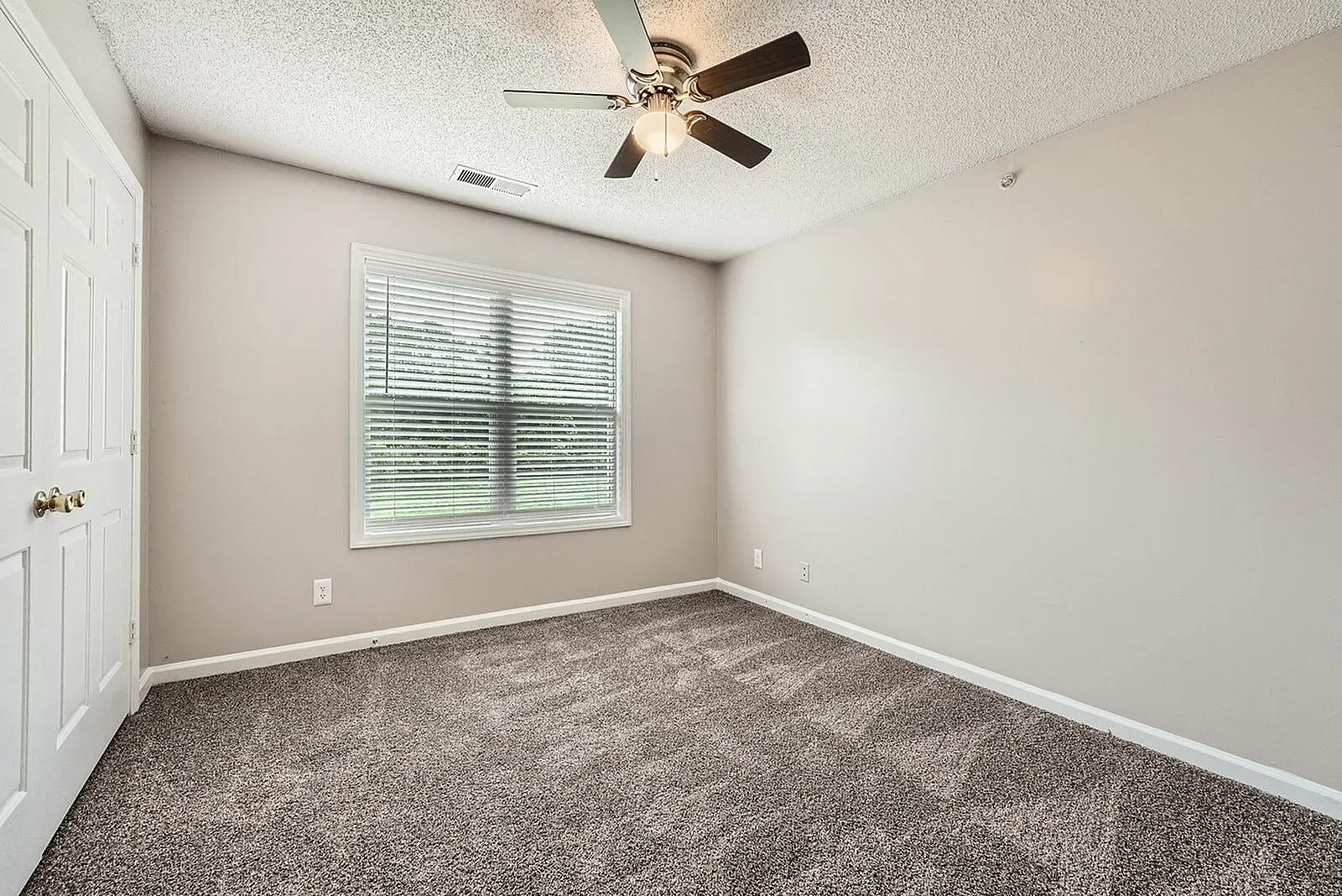 Bedroom, carpet flooring, ceiling fan with light fixture, large window with blinds