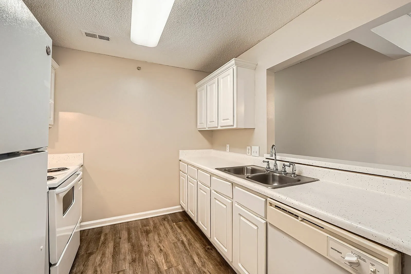 Kitchen, white cabinetry, quartz countertops, stainless sink, wood-style plank flooring