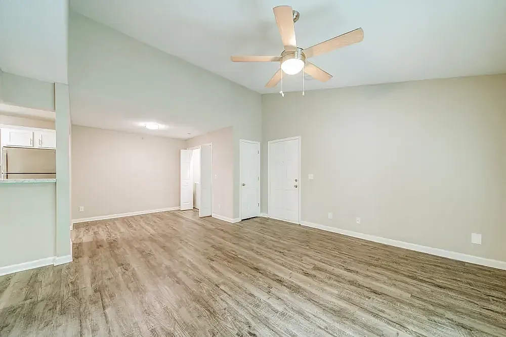 Living room, wood-style plank flooring, ceiling fan with light, white doors